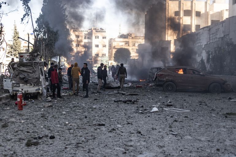 02 December 2024, Syria, Idlib: Vehicles burn while people inspect the damage caused by a Russian air strike on Idlib University. At least 11 people, including five children, were killed when Syrian and Russian warplanes launched a series of air strikes on rebel-held areas in north-western Syria on Monday, activists and a monitor group said. Photo: Anas Alkharboutli/dpa (Photo by Anas Alkharboutli/picture alliance via Getty Images)