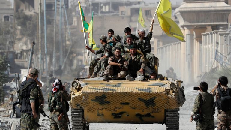 Fighters of Syrian Democratic Forces ride atop of an armoured vehicle after Raqqa was liberated from the Islamic State militants, in Raqqa, Syria October 17, 2017. REUTERS/Erik De Castro