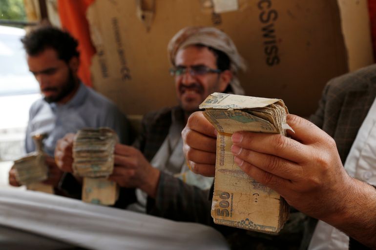 SANA'A, YEMEN - AUGUST 24: A Yemeni wheat merchant counts the money from selling flour and wheat at his shop on August 24, 2021. In Monday's UN Security Council's session, Yemen's former Special Envoy Martin Griffiths, briefs that as a result of more than six years of war and blockade, almost 21 million people, including 11.3 million children, depend on humanitarian assistance to survive. Among them 2.3 million children who are acutely malnourished and nearly 400,000 children under five suffering from severe acute malnutrition are at imminent risk of death. As the war continues, the Yemeni Riyal (YER) hit a historic low to be trading at over YER 1,000 to One USD, in areas under the Internationally-recognized government, and YER 6,00 in the north, which resulted in food prices soaring across the country, exacerbating the risk of famine and put many unable to afford their families basic needs. (Photo by Mohammed Hamoud/Getty Images)