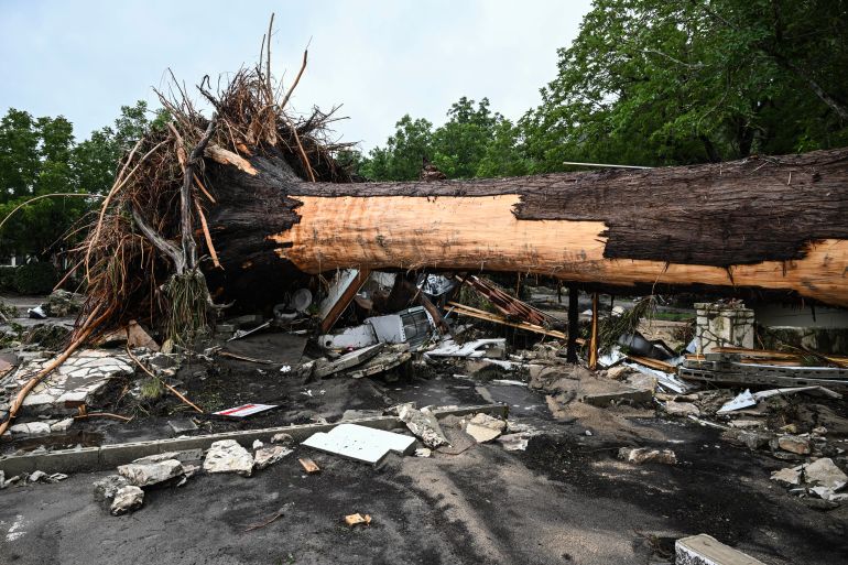 A large tree is uprooted outside of a home near Camp Mystic, the site of where at least 20 girls went missing after flash flooding in Hunt, Texas, on July 5, 2025.