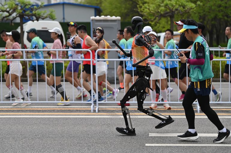 19 April 2025, China, Peking: The humanoid robot "Tian Gong" runs a half marathon with a coworker. In Beijing, humanoid robots competed against humans in a half marathon. Photo: Johannes Neudecker/dpa (Photo by Johannes Neudecker/picture alliance via Getty Images)